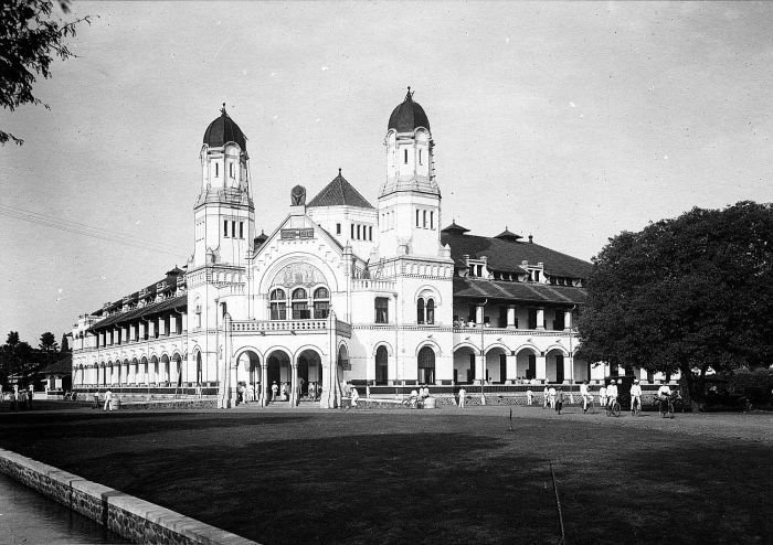 A historical image of Lawang Sewu during the Dutch colonial period, with soldiers guarding its entrance.